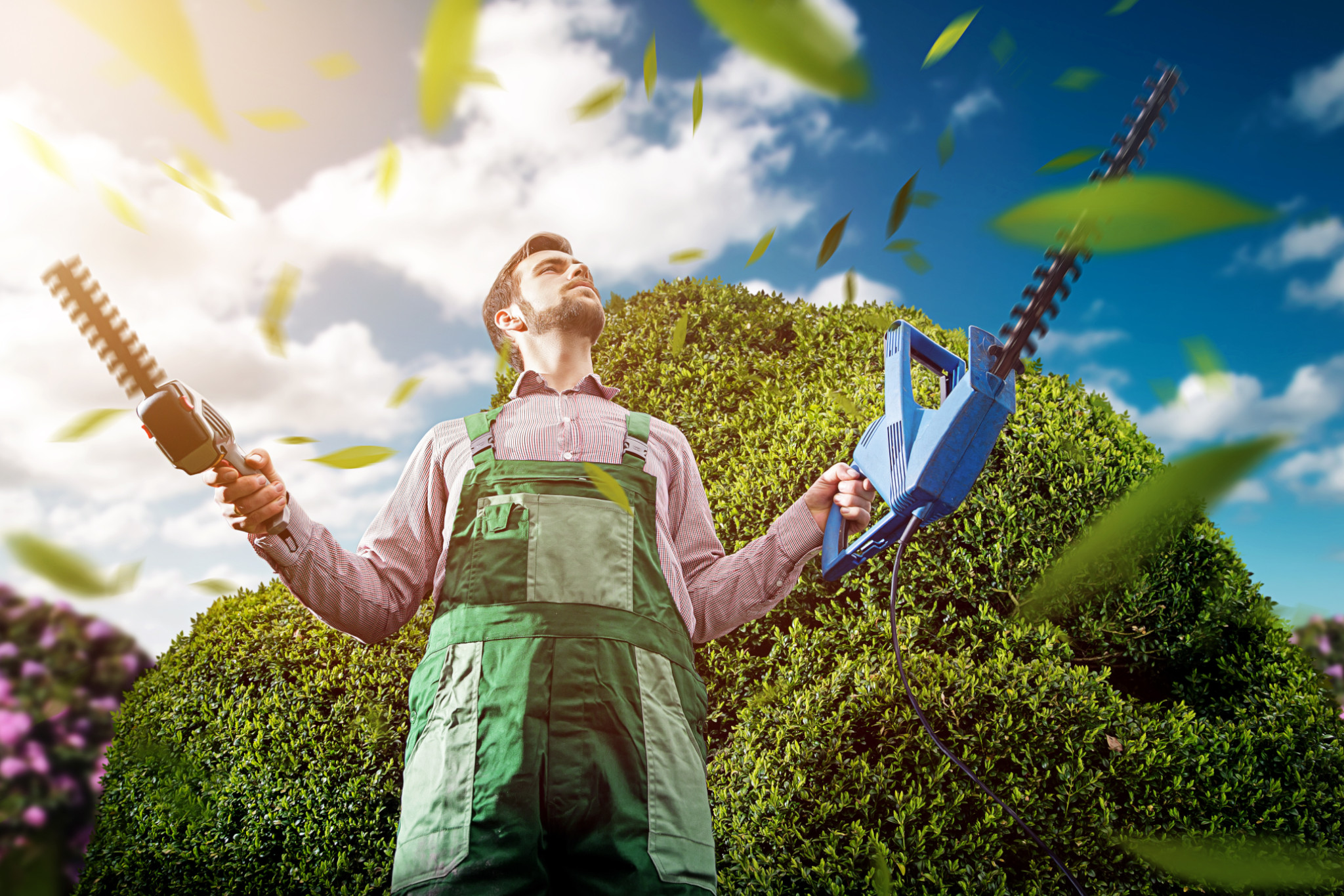 Bäume schneiden: Mann mit Sägen in der Hand im Garten