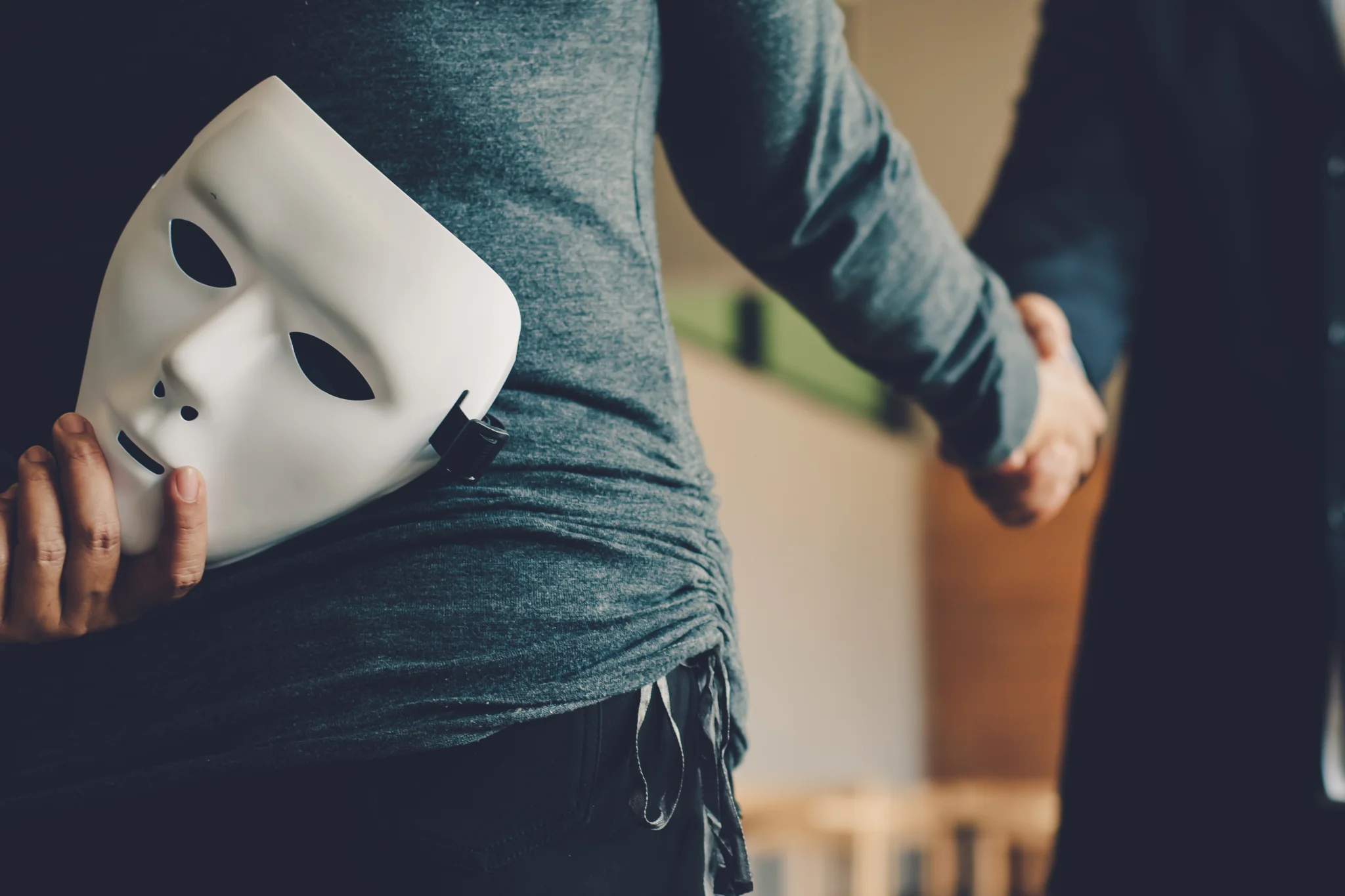 mann versteckt maske hinterm rücken (betrug)