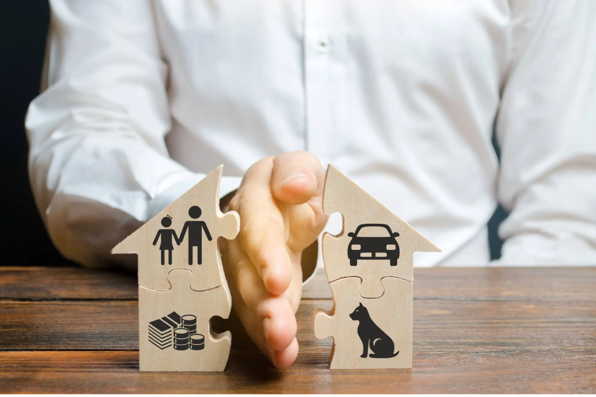Trennung Versicherung, Person hält Hand zwischen zwei Puzzle-Haushälften