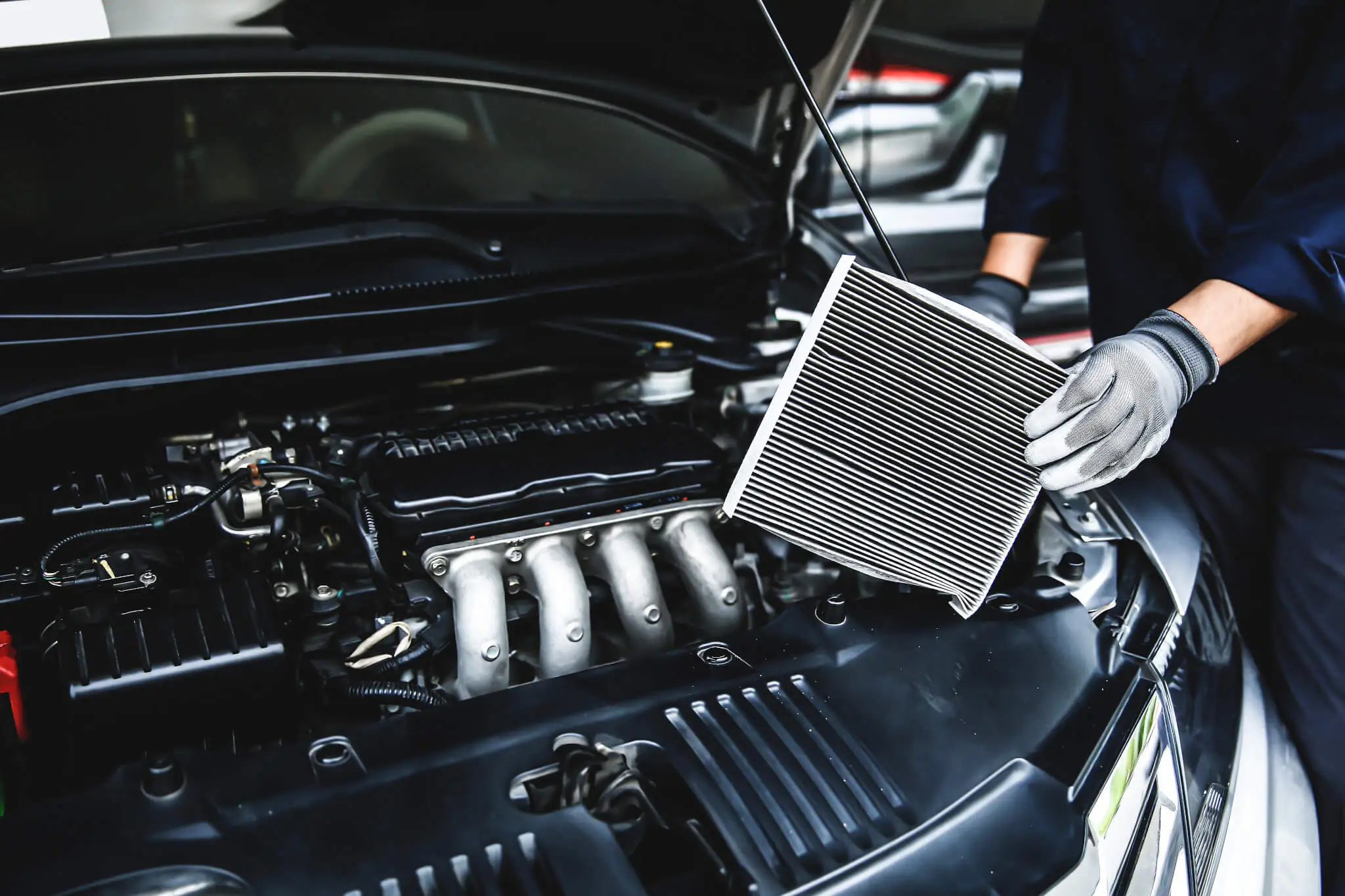 Mechaniker:in tauscht Auto Luftfiter aus